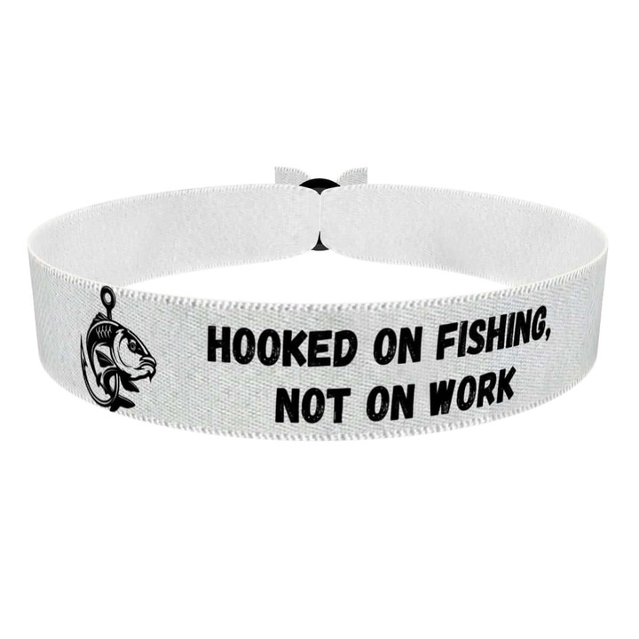 Zum Produkt Stoffarmband mit dem Motiv Hooked on Fishing Not on Work